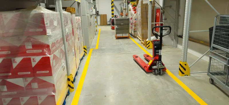 Crvene sigurnosne oznake i transportni putevi u industrijskoj hali