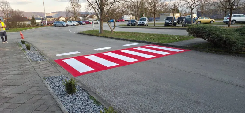 Pješački prijelaz na crvenoj podlozi s bijelim oznakama